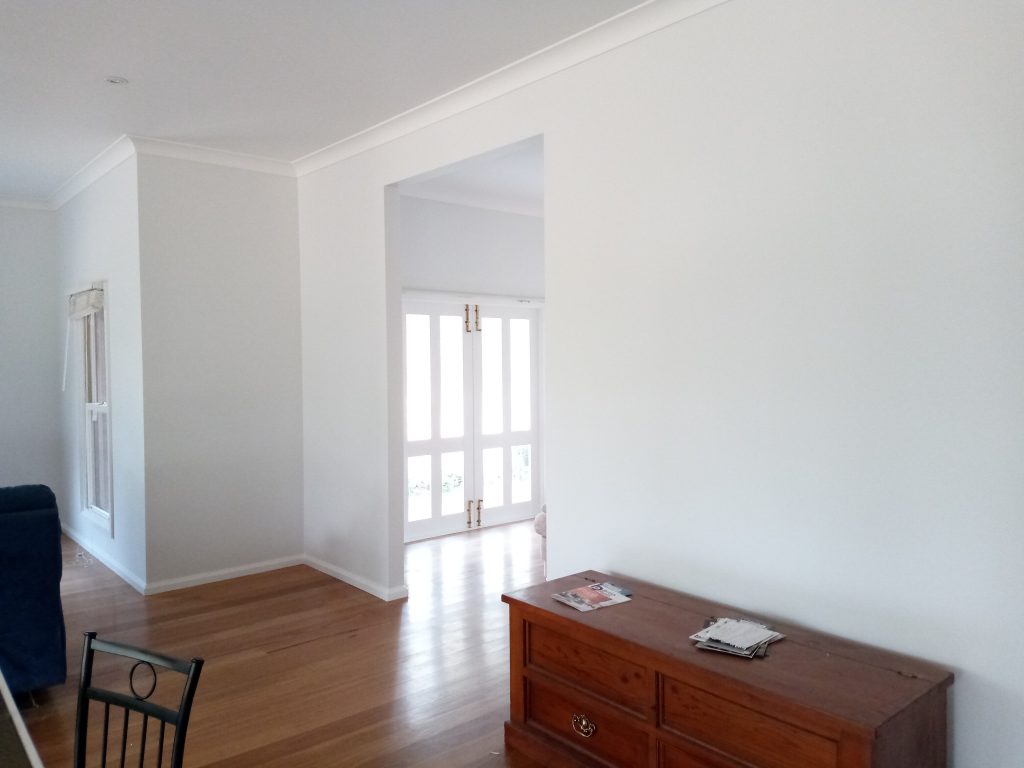 Interior of house with white walls and a wooden cabinet against the wall