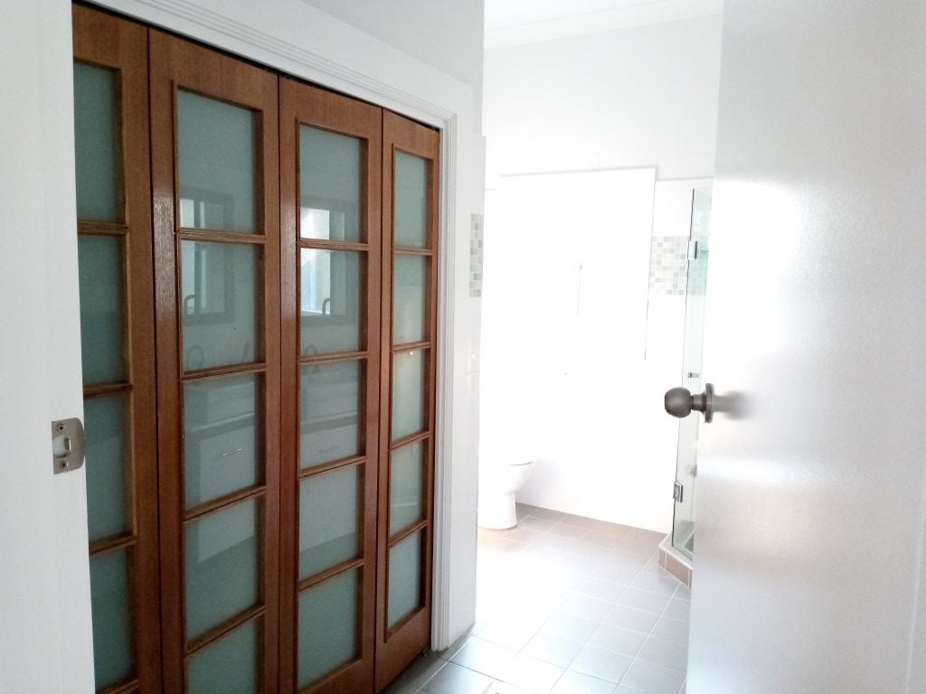 Wooden glass cupboard against a freshly painted wall